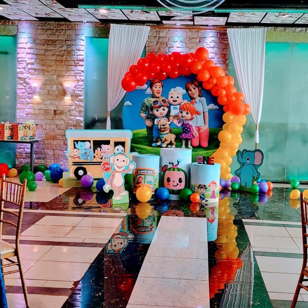 A Guru Palace party room decorated with Cocomelon characters, balloons, and colorful balls on the floor.